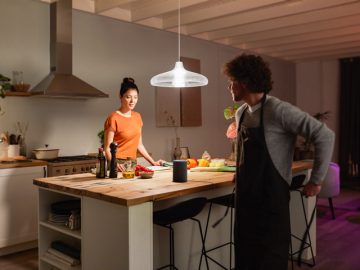 Pareja en la cocina usando Bluetooth, Alexa y hue