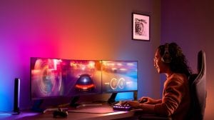 Personne jouant à un jeu vidéo à un bureau éclairé par des lumières intelligentes colorées qui se synchronisent avec le PC, améliorant l’expérience de divertissement immersive.