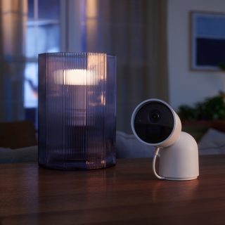 Caméra de sécurité pour la maison intelligente sur une table à côté d'une lampe intelligente