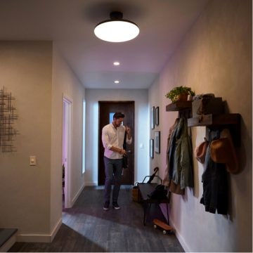 Homme mettant son manteau dans l'entrée d'une maison