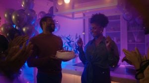 Groupe de personnes célébrant joyeusement une fête animée sous un éclairage d'ambiance dynamique qui souligne l'atmosphère festive et énergique.