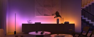 Soggiorno con bagliore per un'atmosfera soft proveniente dall'illuminazione sotto i mobili smart in porpora e arancione, che mette in evidenza decorazioni e opere d'arte moderne. 