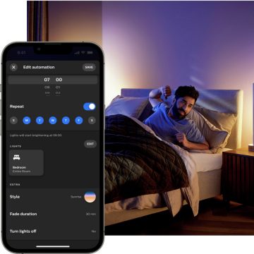 ベッドで眠る女性。ベッドサイドランプにはスマート照明で赤とオレンジのほの暗い灯りがともる