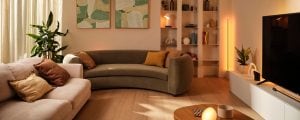 A living room lit with soft white mood lighting using concealed LED strip lights and smart lamps, creating a relaxing ambiance.