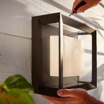 A outdoor wall light being installed.
