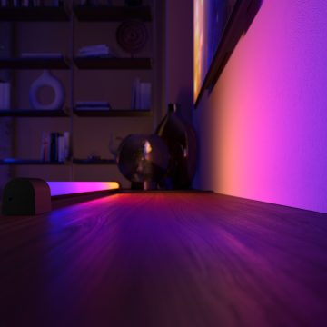 Hue 智能渐变光灯管将蓝、粉、紫和黄色调的多彩灯光投射在墙面上。